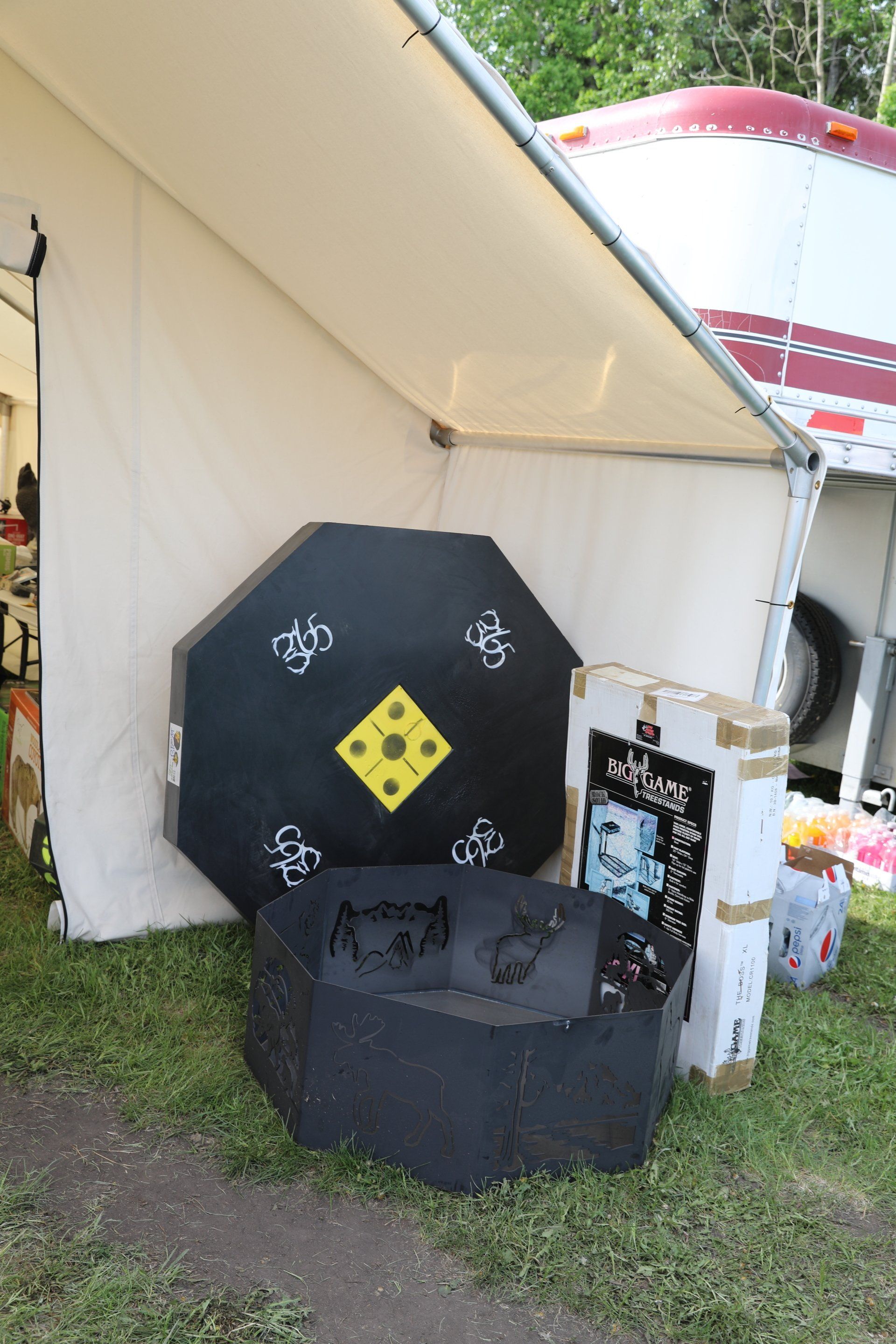 A target is sitting in the grass under a tent.