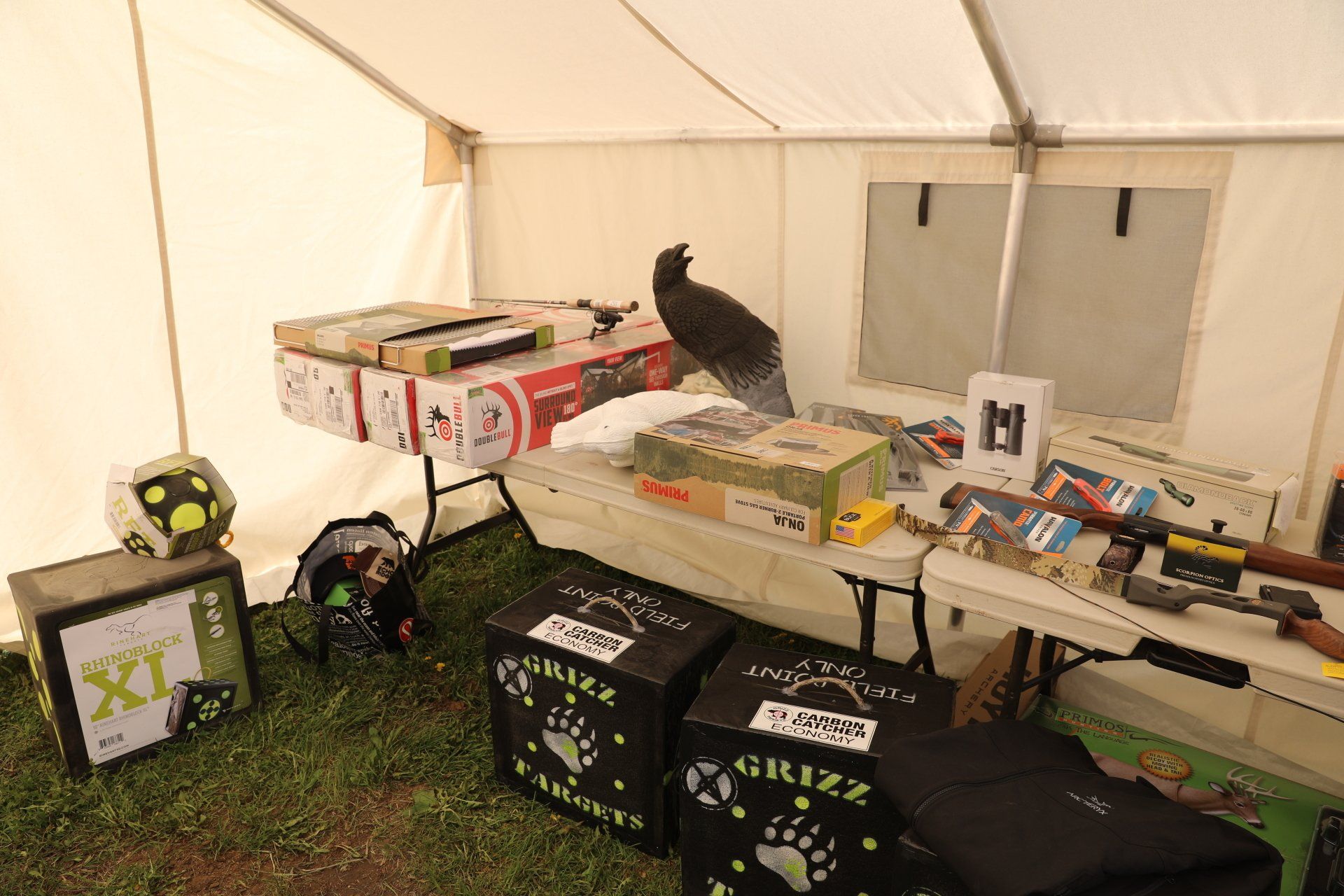 A tent filled with lots of boxes and a bird sitting on top of a table.