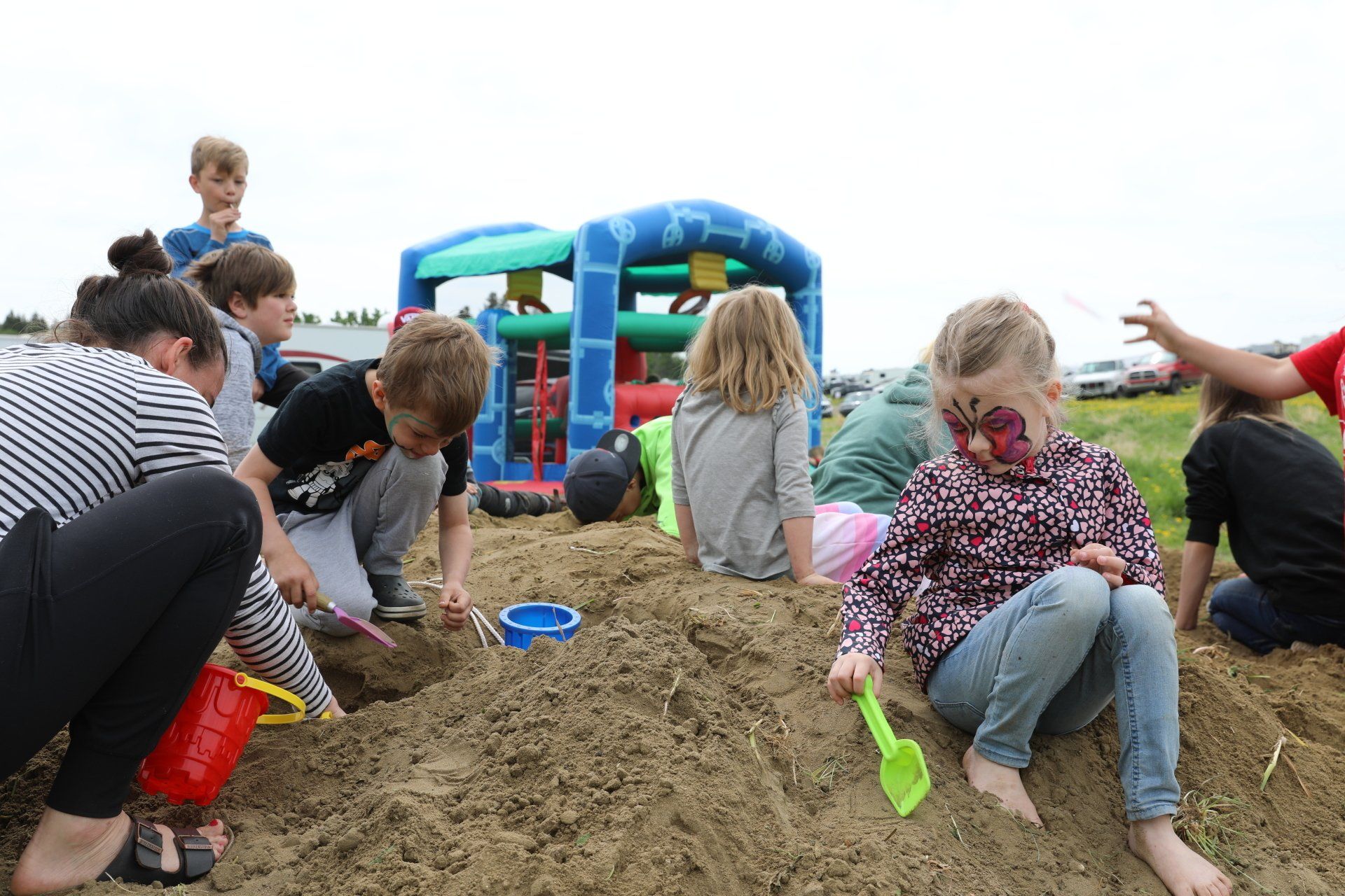 A group of children are playing in a sandbox.