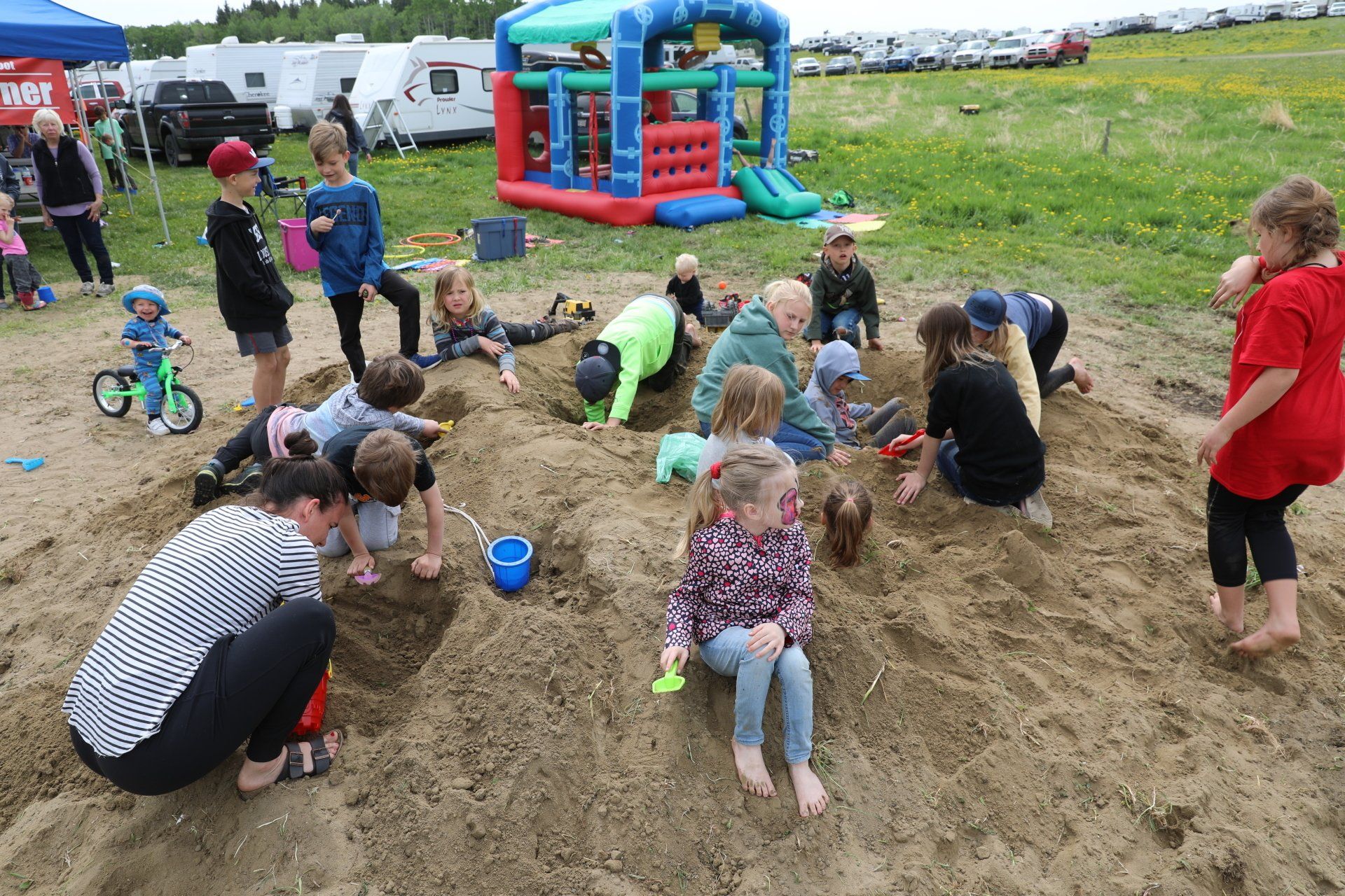 A group of children are playing in a sandbox.