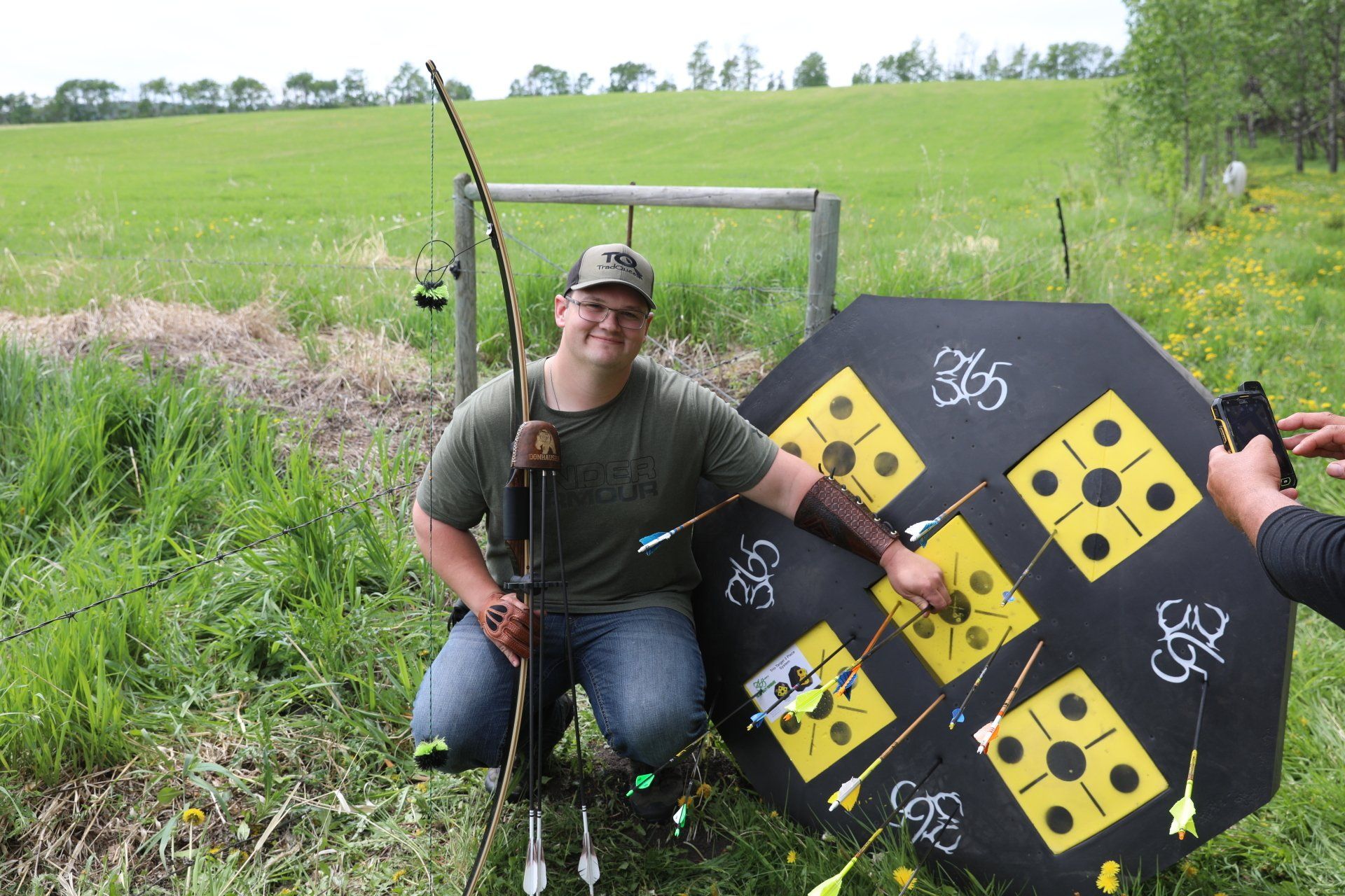 Man sitting by archery target.