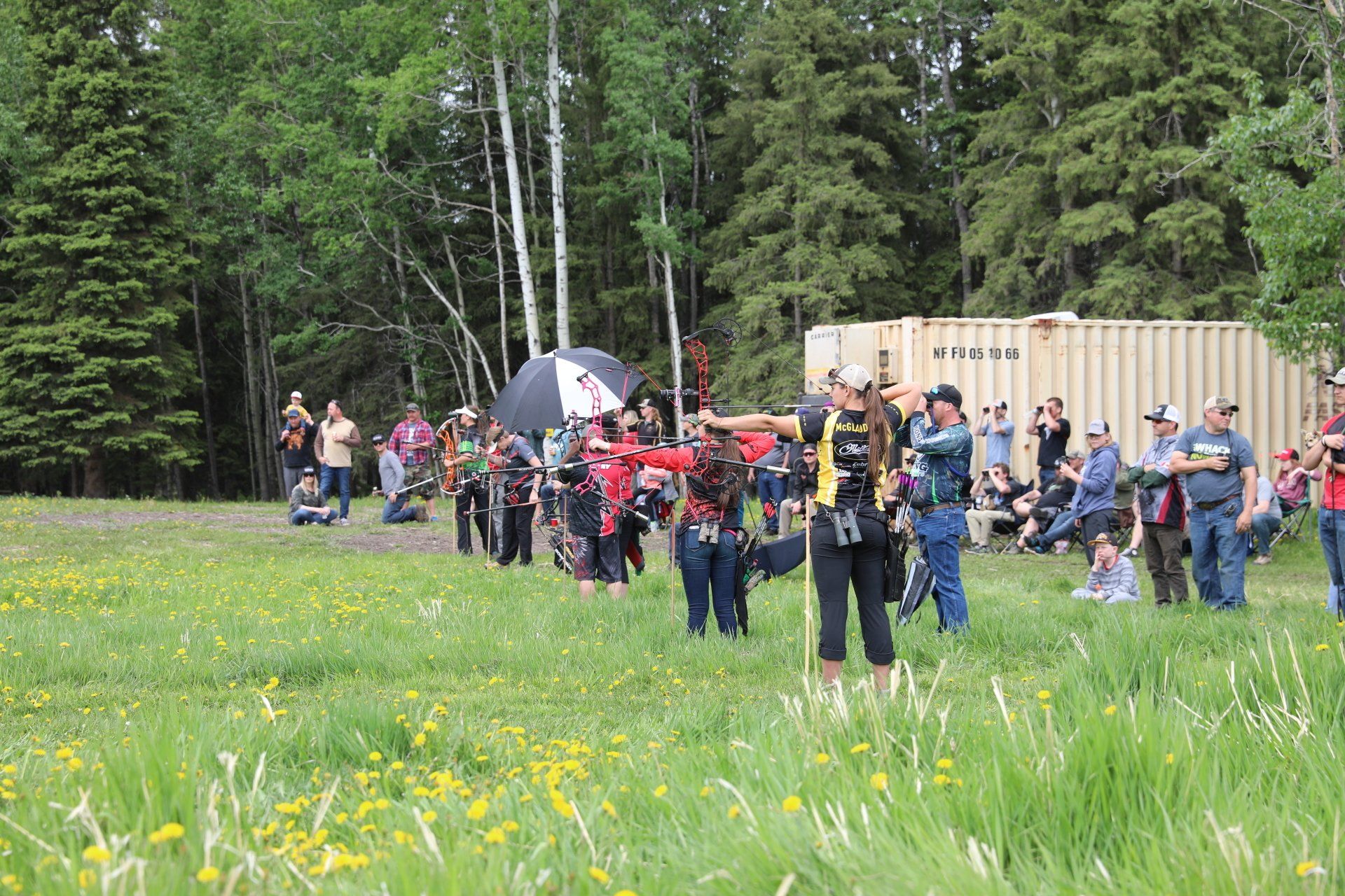 A group of people are standing in a grassy field.