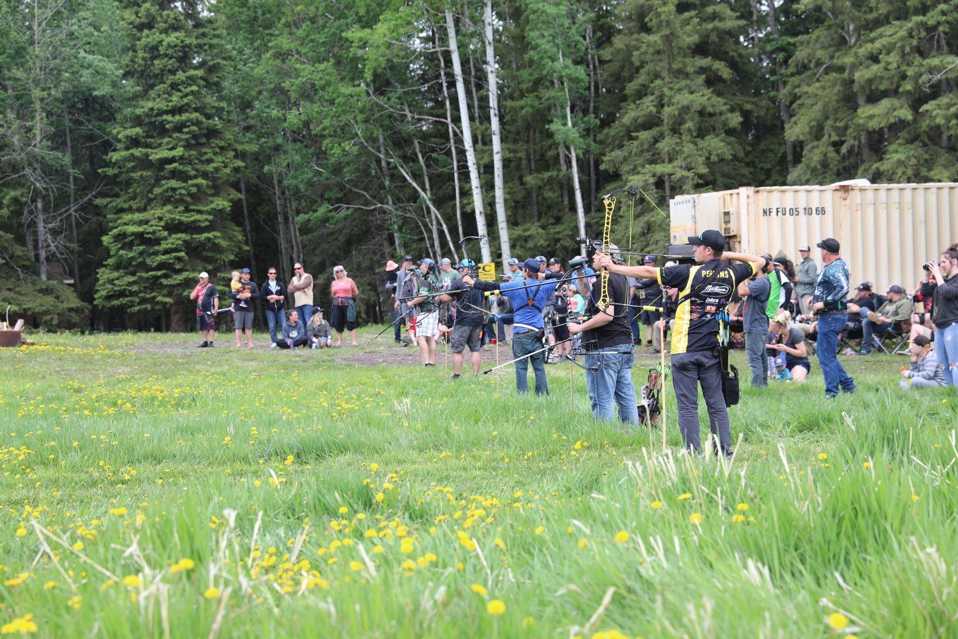 A group of people are standing in a grassy field.