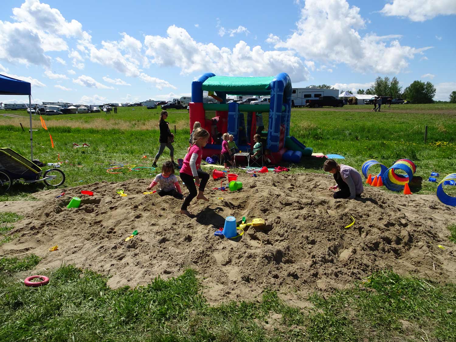 A group of children are playing in a sandbox in a field.