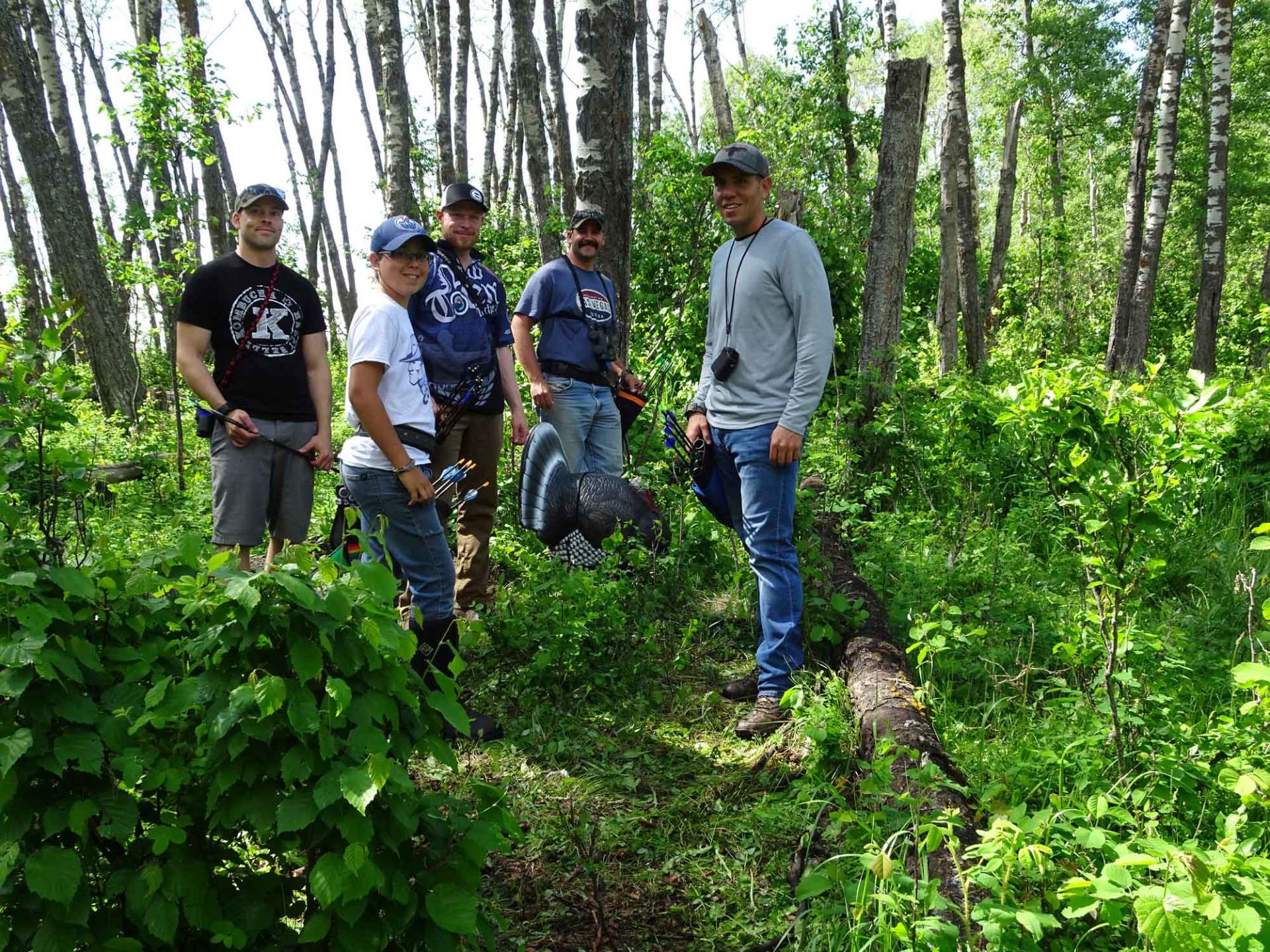 A group of men are standing in the middle of a forest.