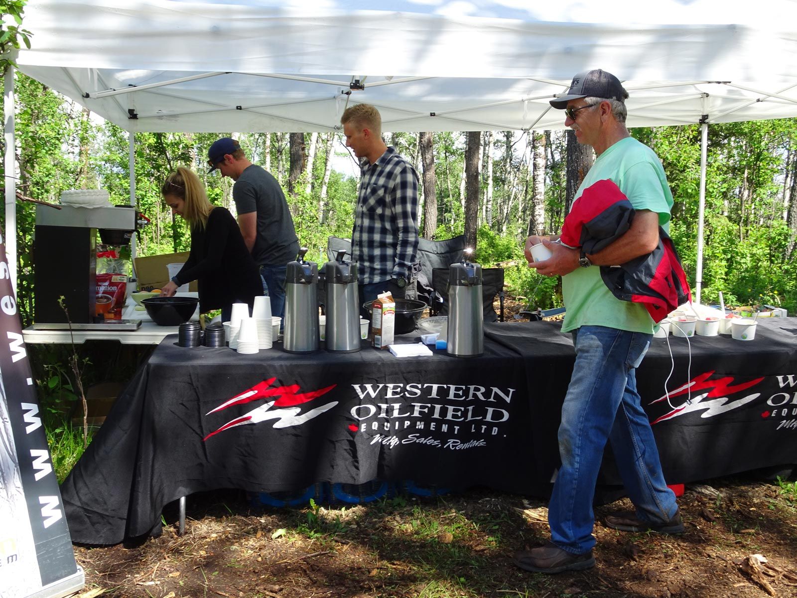 A group of people standing around a table that says western oilfield