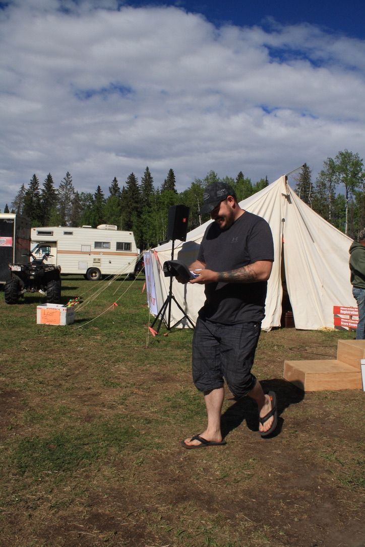 A man standing in a field with a tent in the background