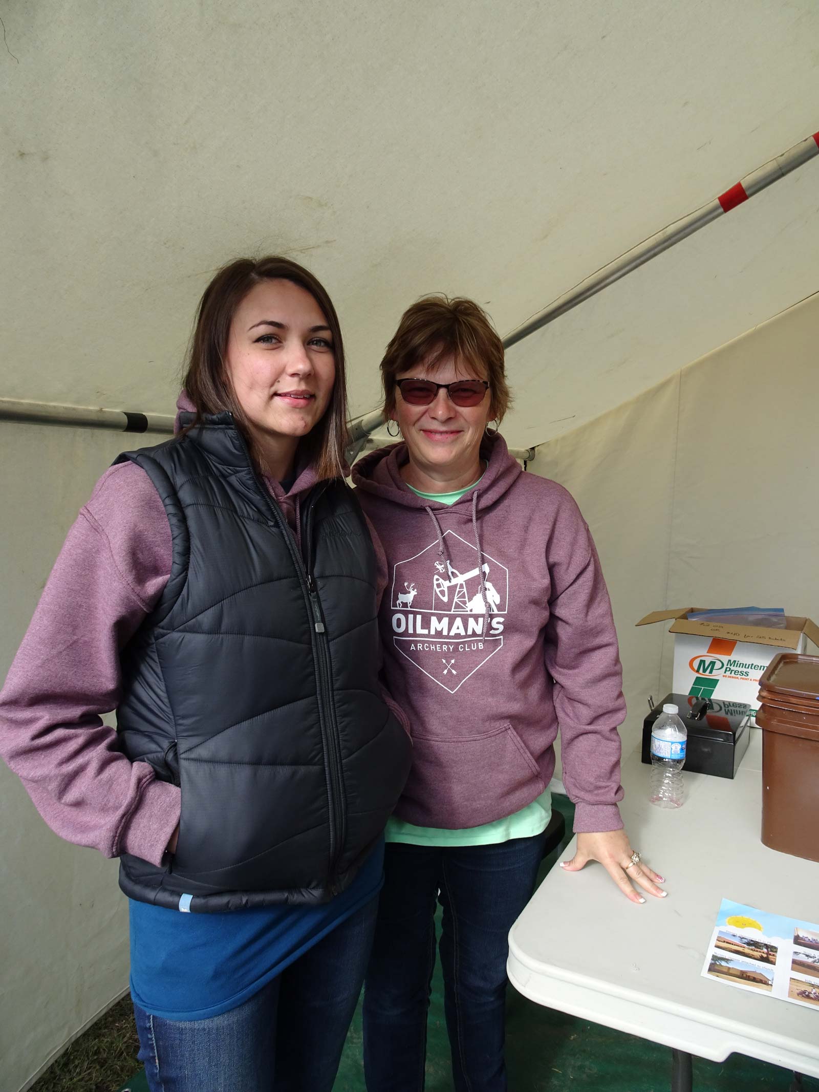 Two women are standing next to each other in a tent.