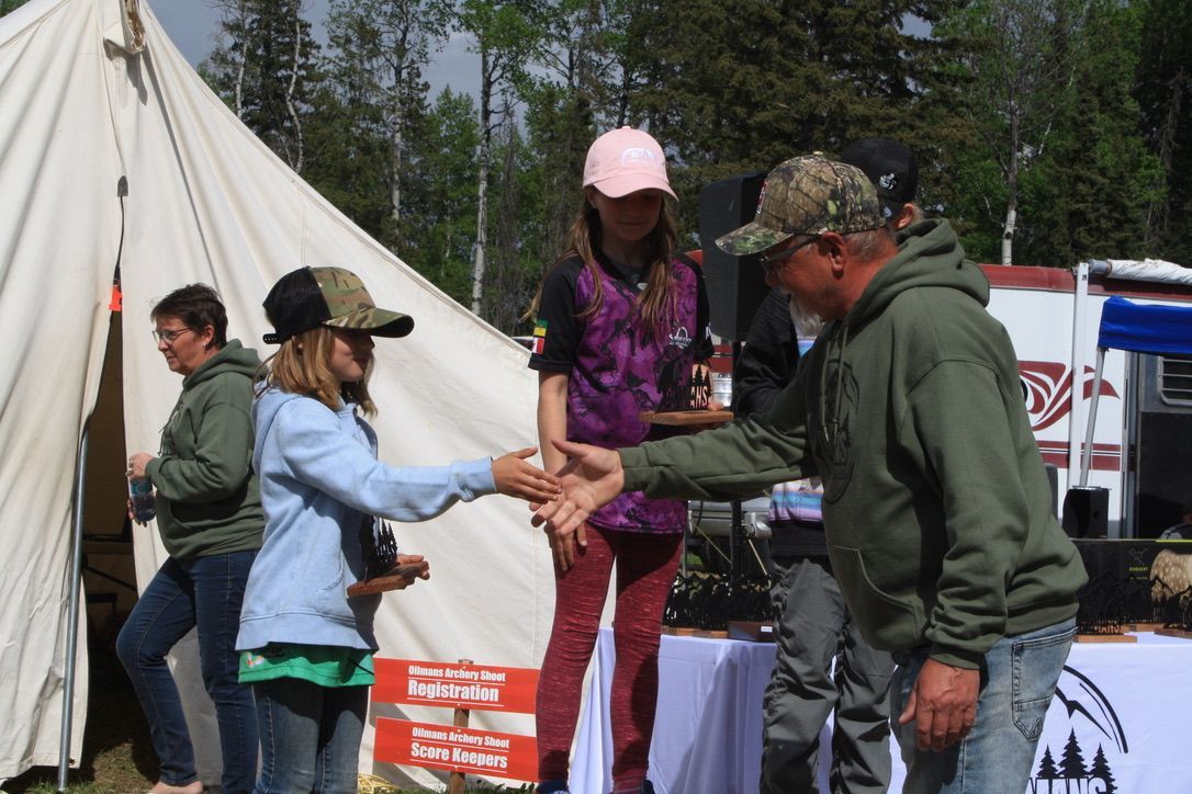 A group of people shaking hands in front of a tent