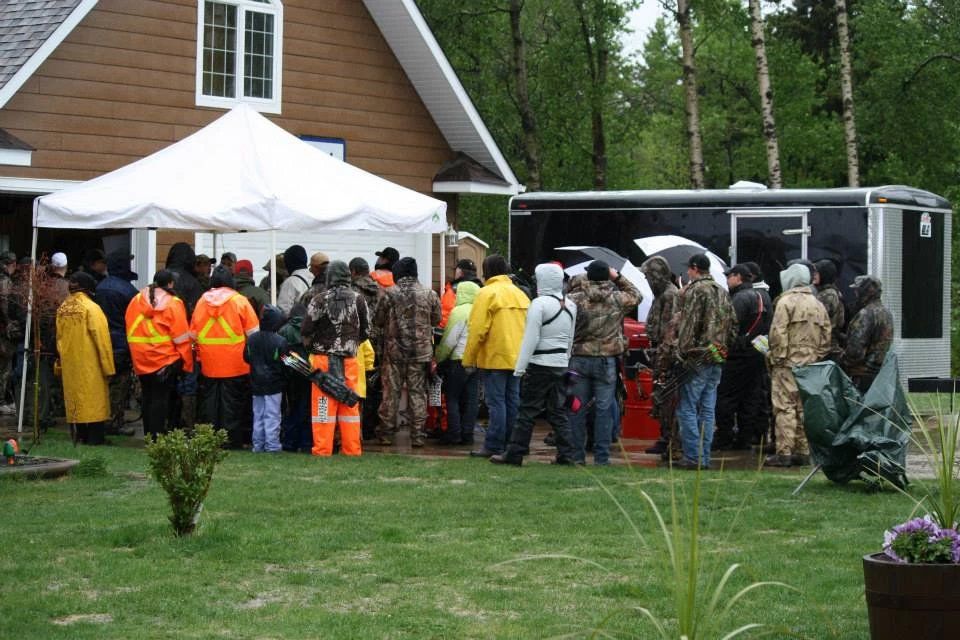 A group of people standing in front of a house