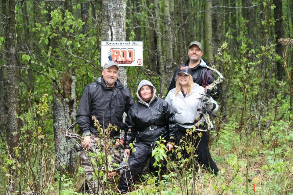A group of people are posing for a picture in the woods.
