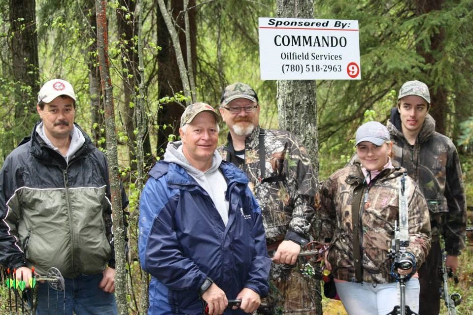 A group of people are standing in front of a commando sign.