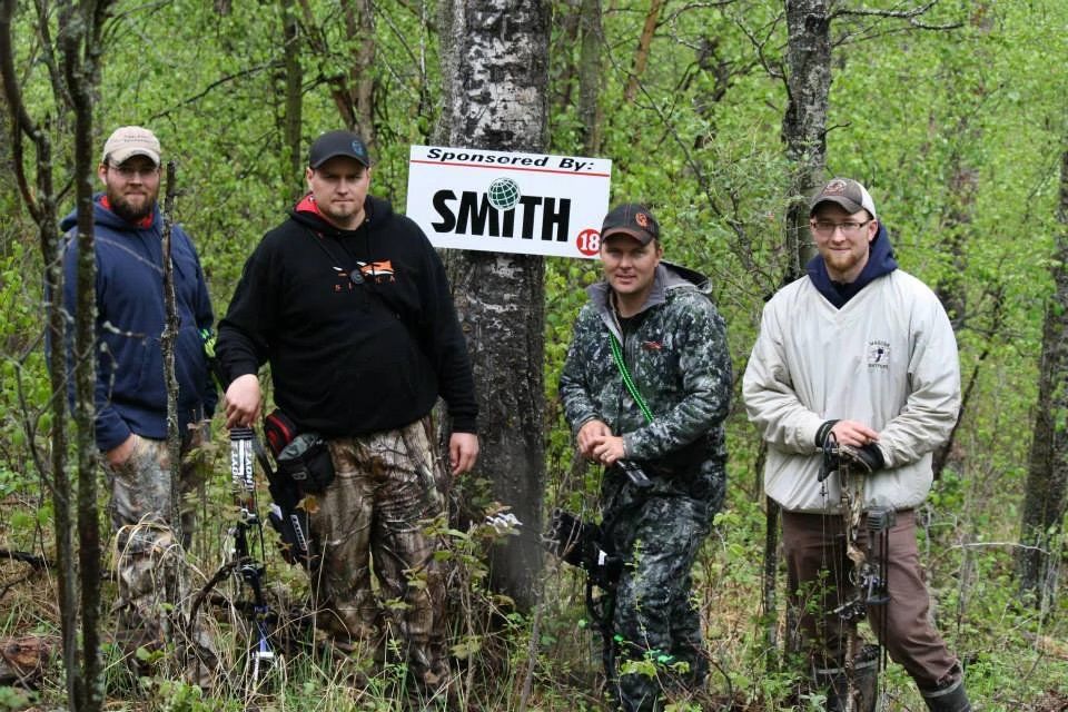 Four men are standing in front of a sign that says smith