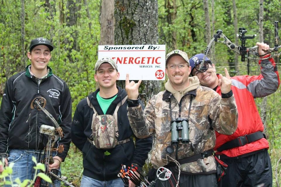 A group of men are standing in front of a sign that says energetic