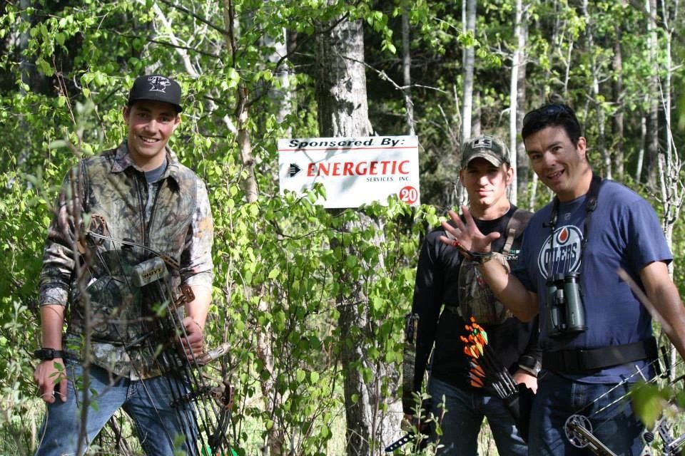 Three men standing in front of a sign that says energetic