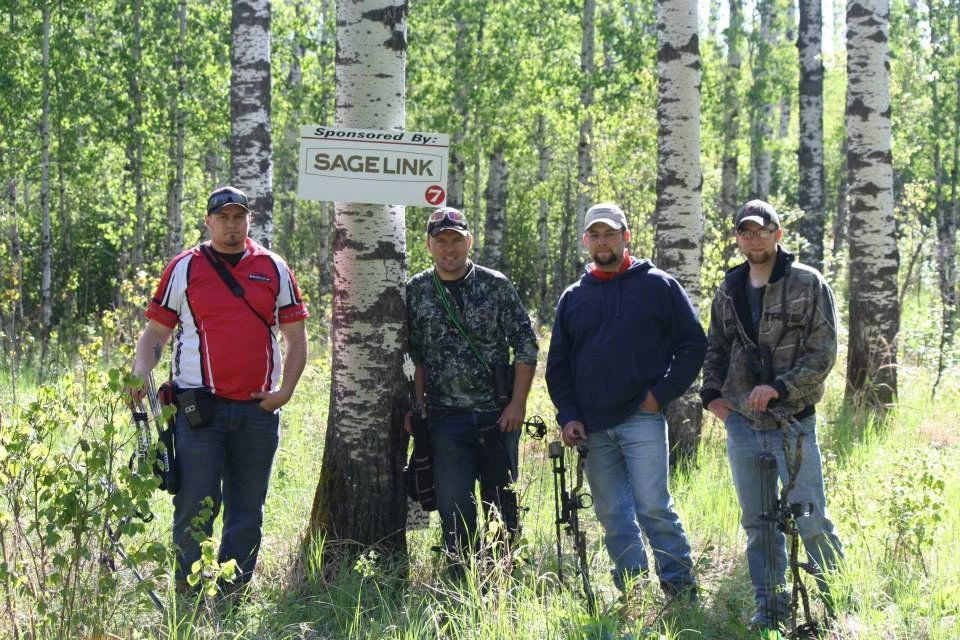 A group of men standing in front of a sign that says sagelink