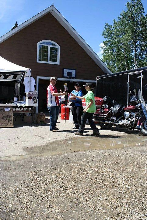 A group of people are standing in front of a building with motorcycles parked in front of it.