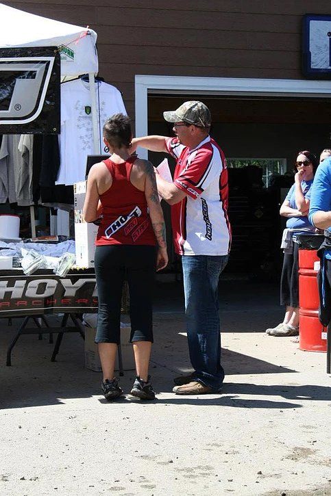 A man and woman are standing in front of a sign that says hoy