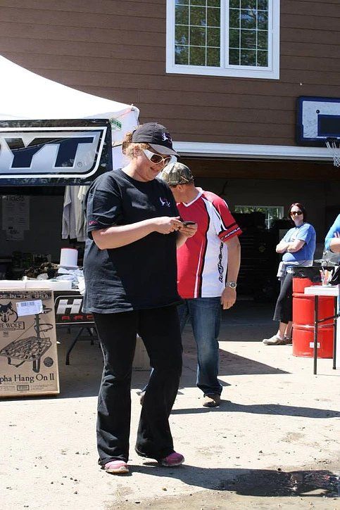 A woman in a black shirt is looking at her phone