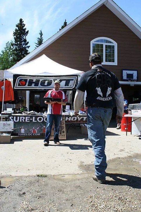 A man in a black shirt walks past a booth that says holt