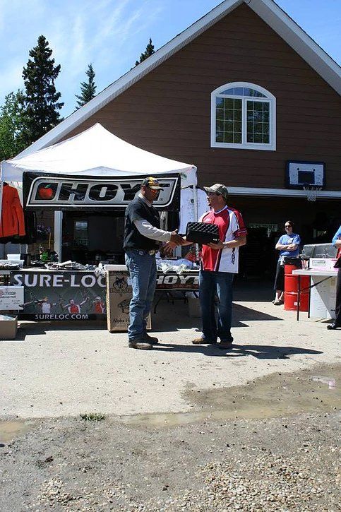 Two men shaking hands in front of a building that says hoy