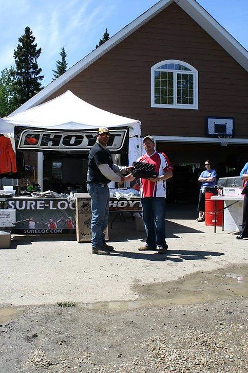 A man is shaking hands with another man in front of a store that says sure-loc