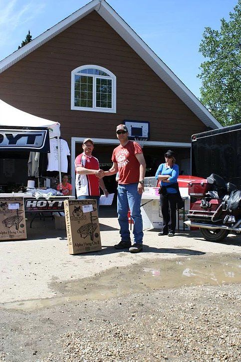 A man shaking hands with another man in front of a house
