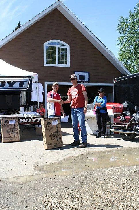 Two men shaking hands in front of a hayt store