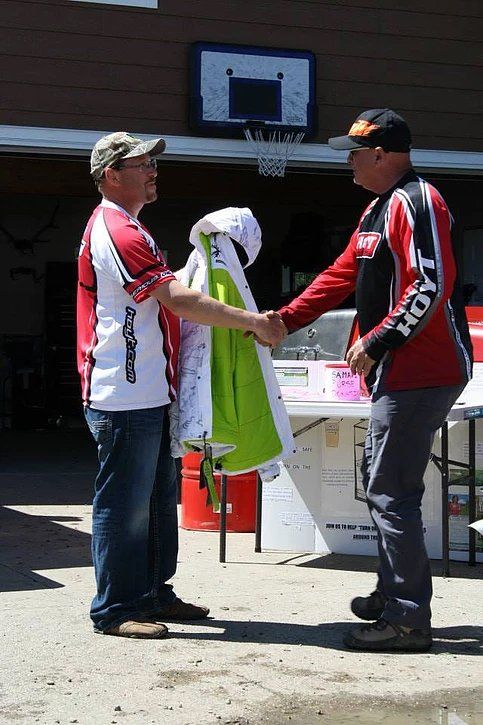 Two men shaking hands in front of a basketball hoop