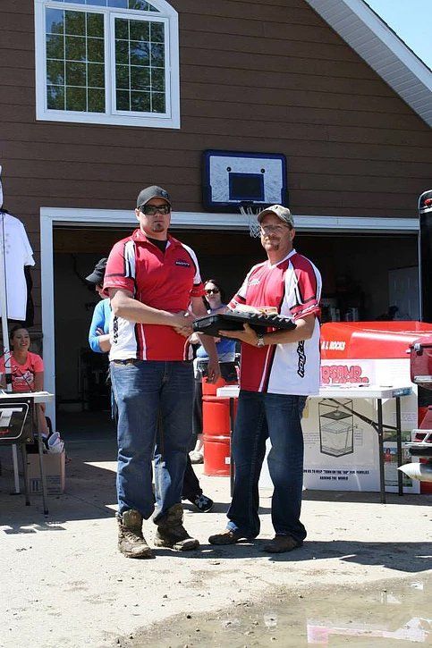 Two men shaking hands in front of a garage door