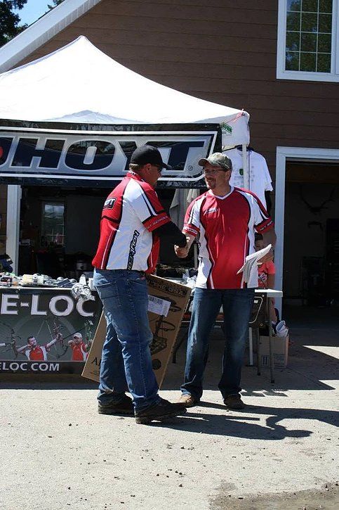Two men standing in front of a sign that says hoyt