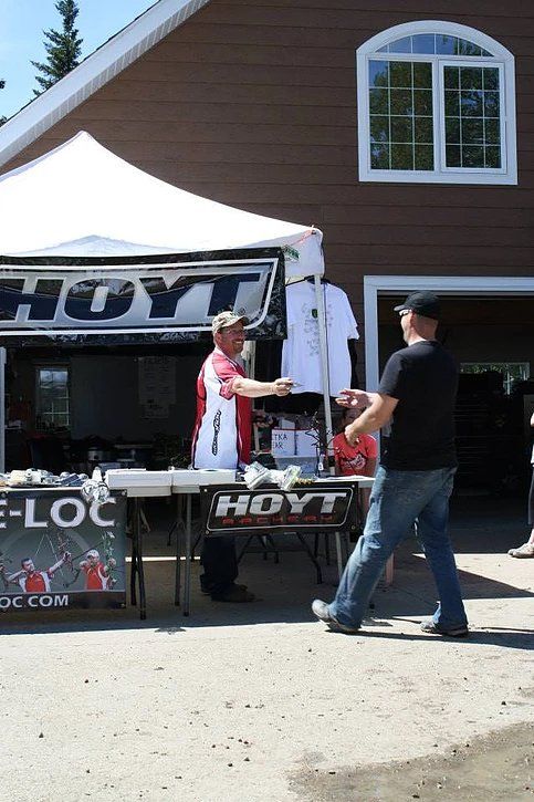 A man is standing in front of a hayt tent