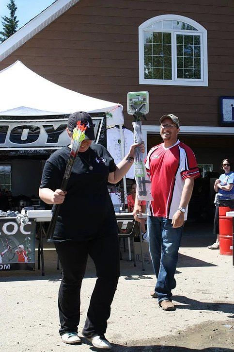 A man in a red shirt stands next to a woman in a black shirt