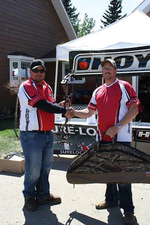 Two men shaking hands in front of a andy tent