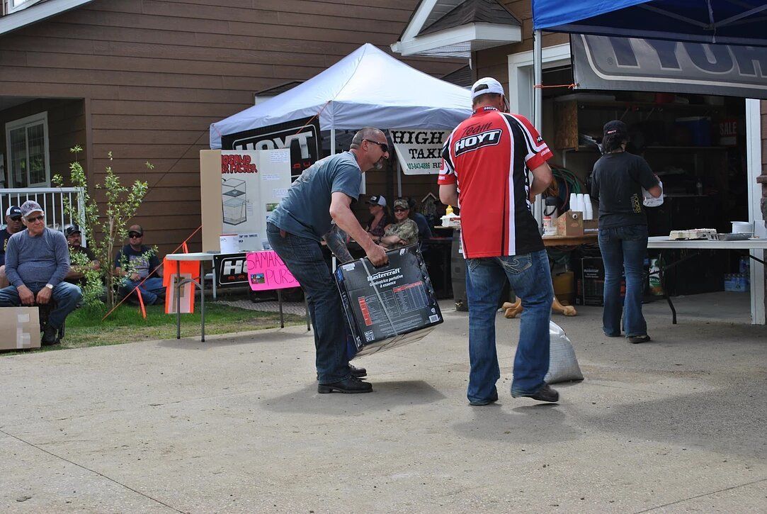 A man in a red shirt is carrying a large bag