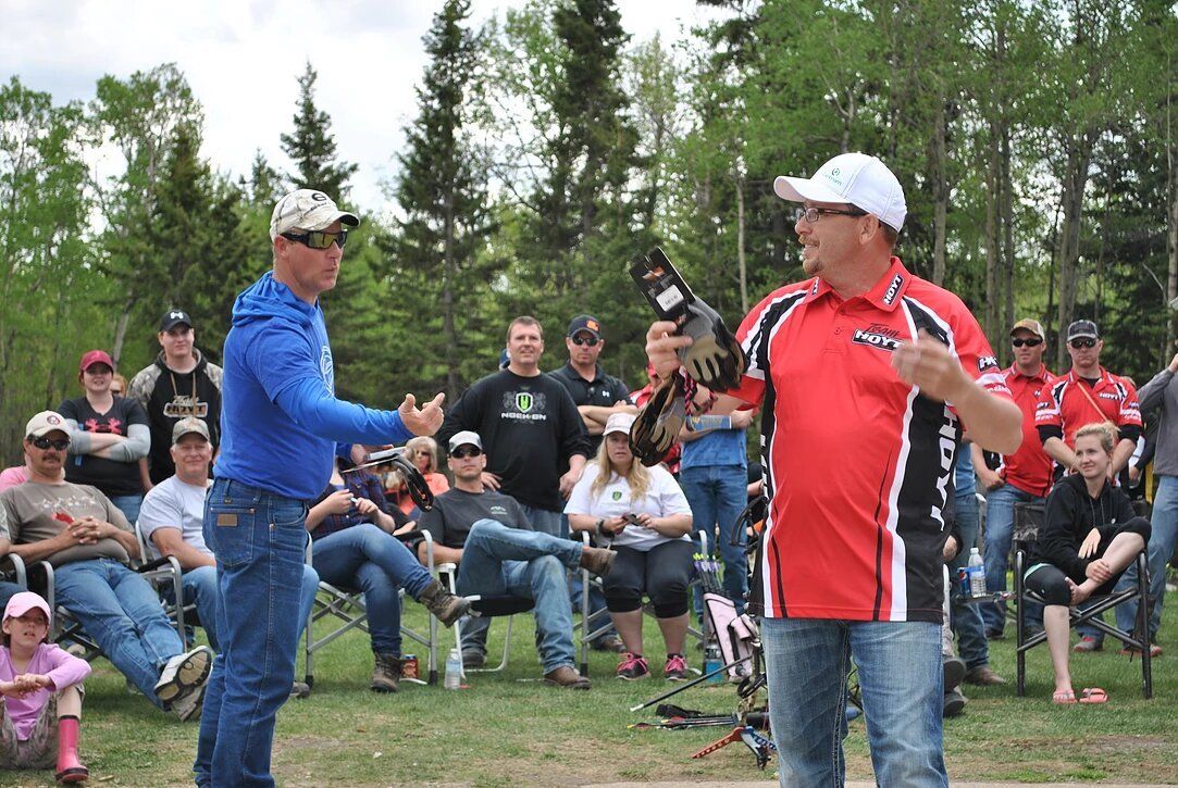 Two men are standing next to each other in front of a crowd of people.