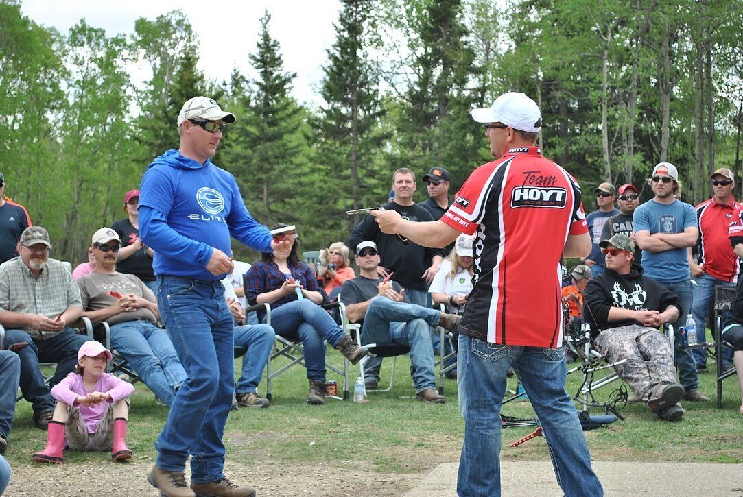 Two men are standing next to each other in front of a crowd of people.