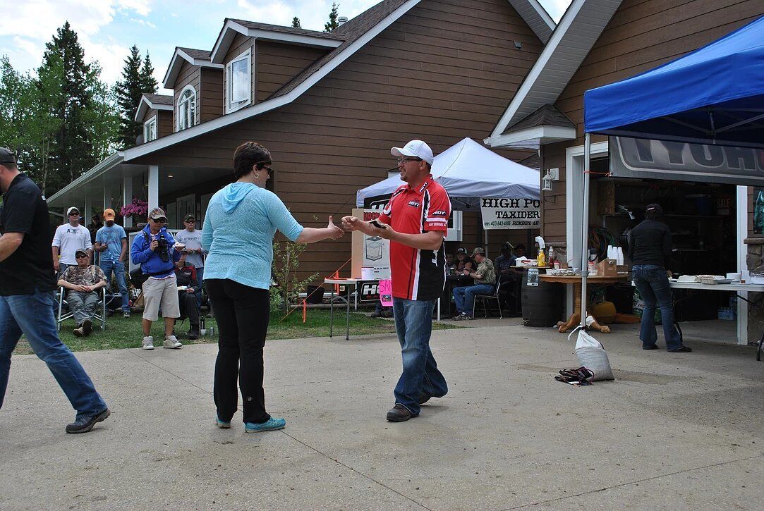 A group of people are dancing in front of a house