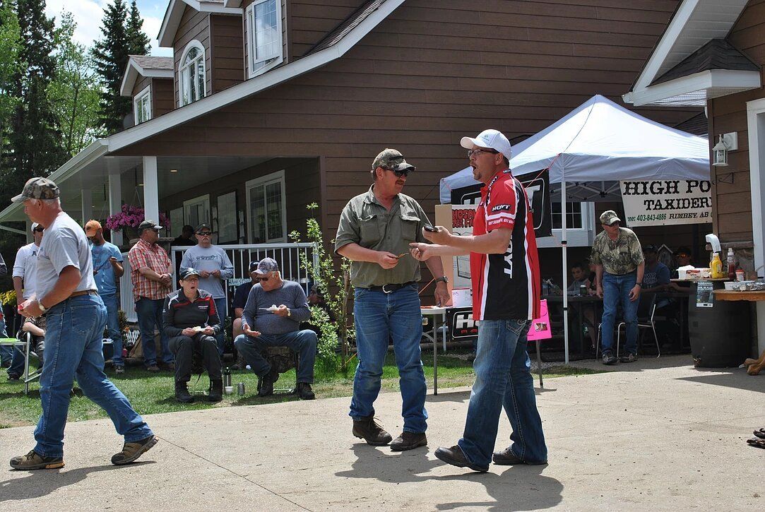 A group of men standing in front of a house with a sign that says tim b td