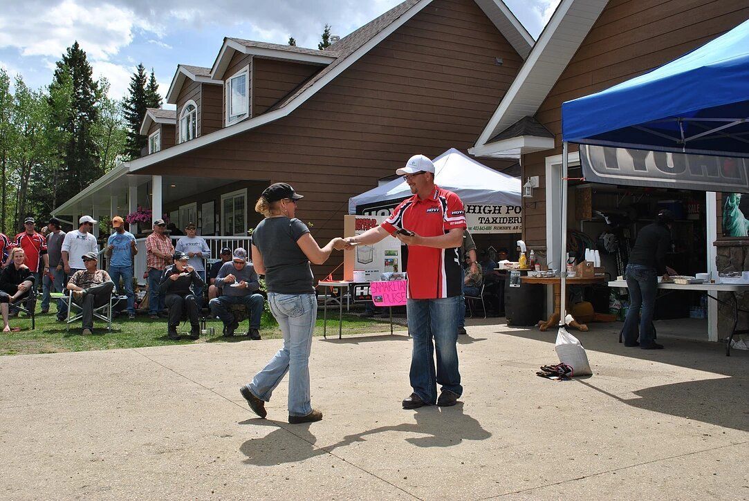A man and a woman are dancing in front of a house
