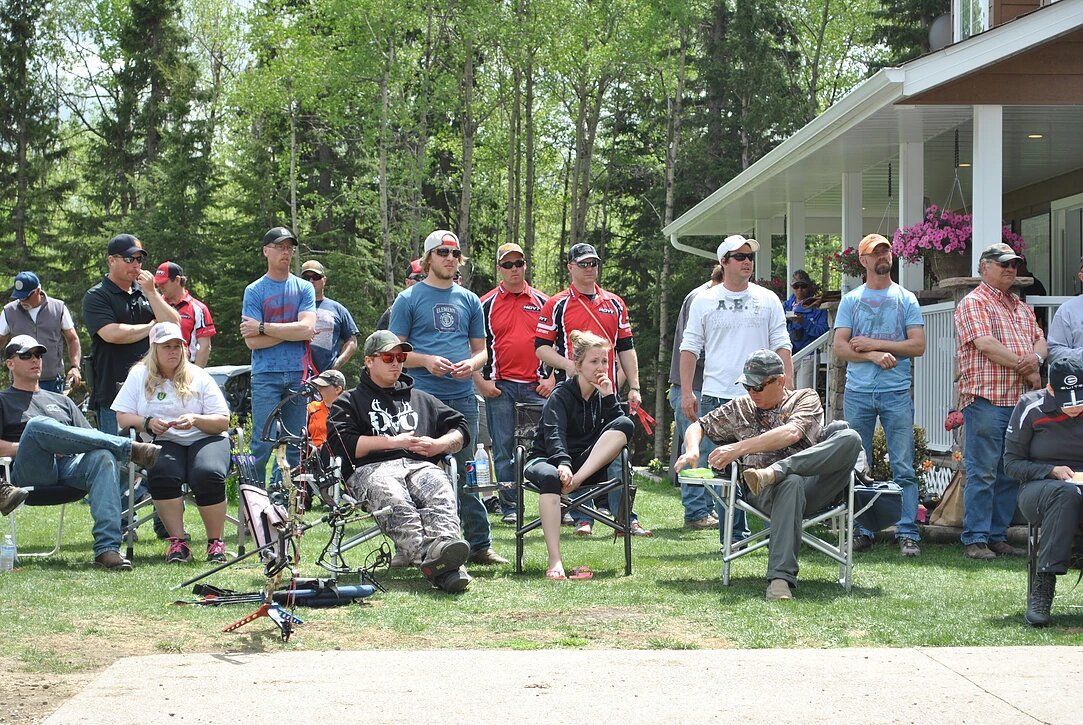 A group of people are sitting in chairs in front of a house.