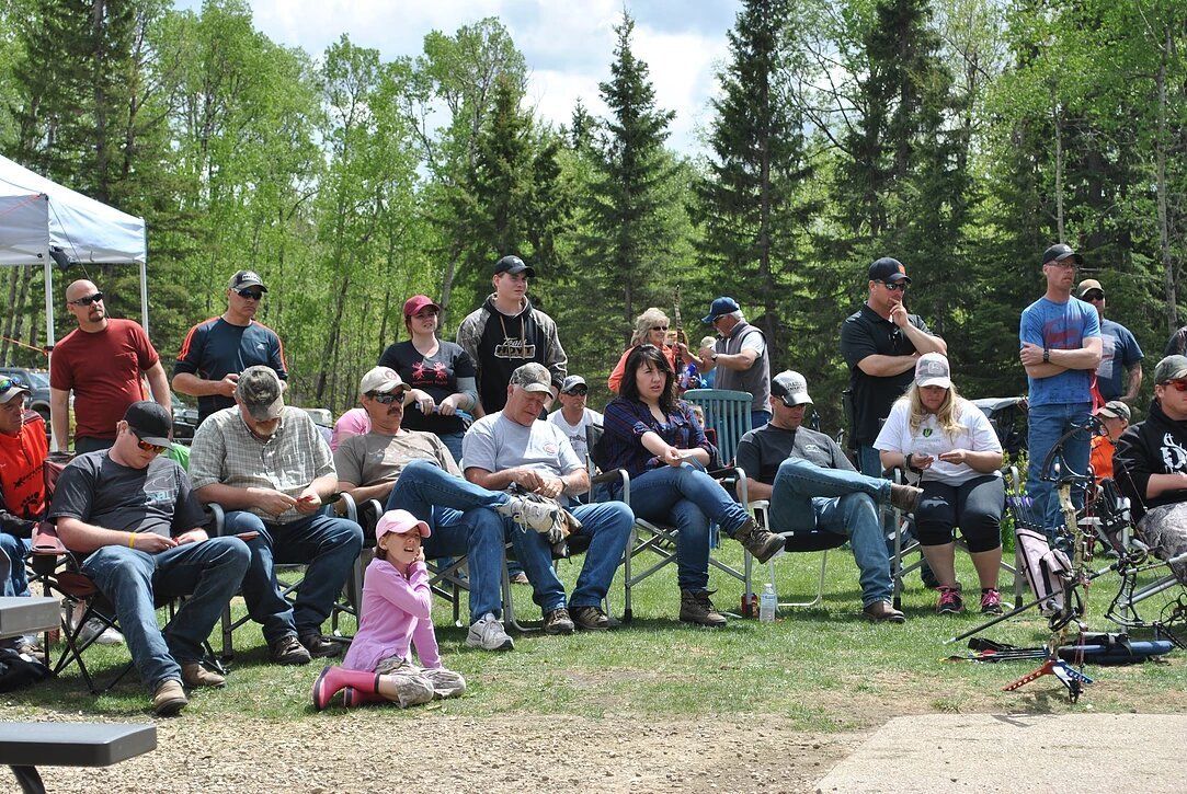 A group of people are sitting in chairs in a field.