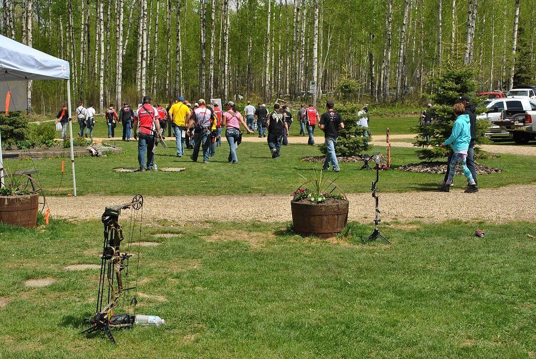 A group of people are standing in a grassy field.