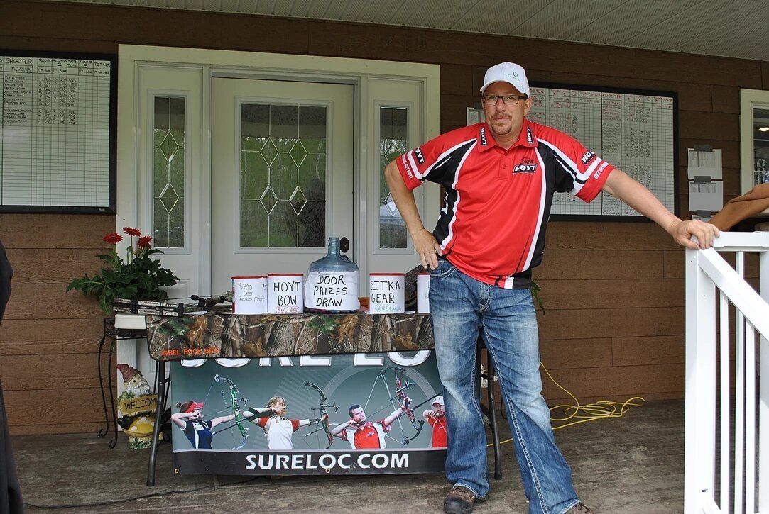 A man standing in front of a table that says sureloc.com