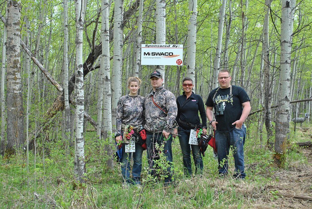 A group of people standing next to each other in a forest.