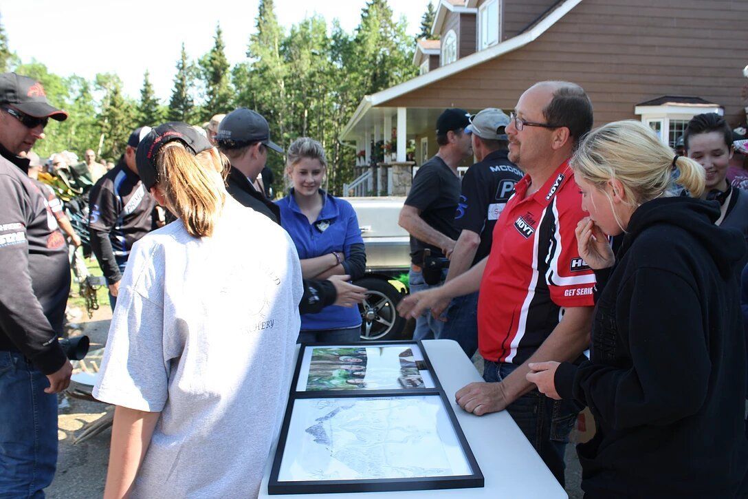 A group of people standing around a table looking at pictures