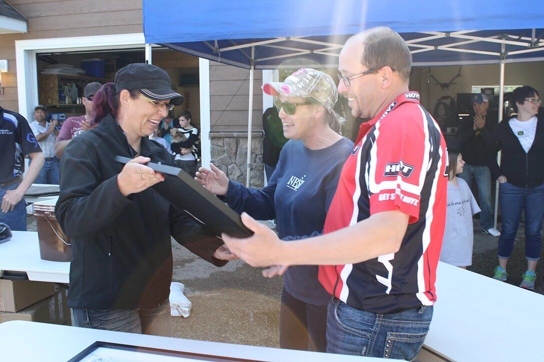 A man in a red shirt is shaking hands with a woman in a blue shirt