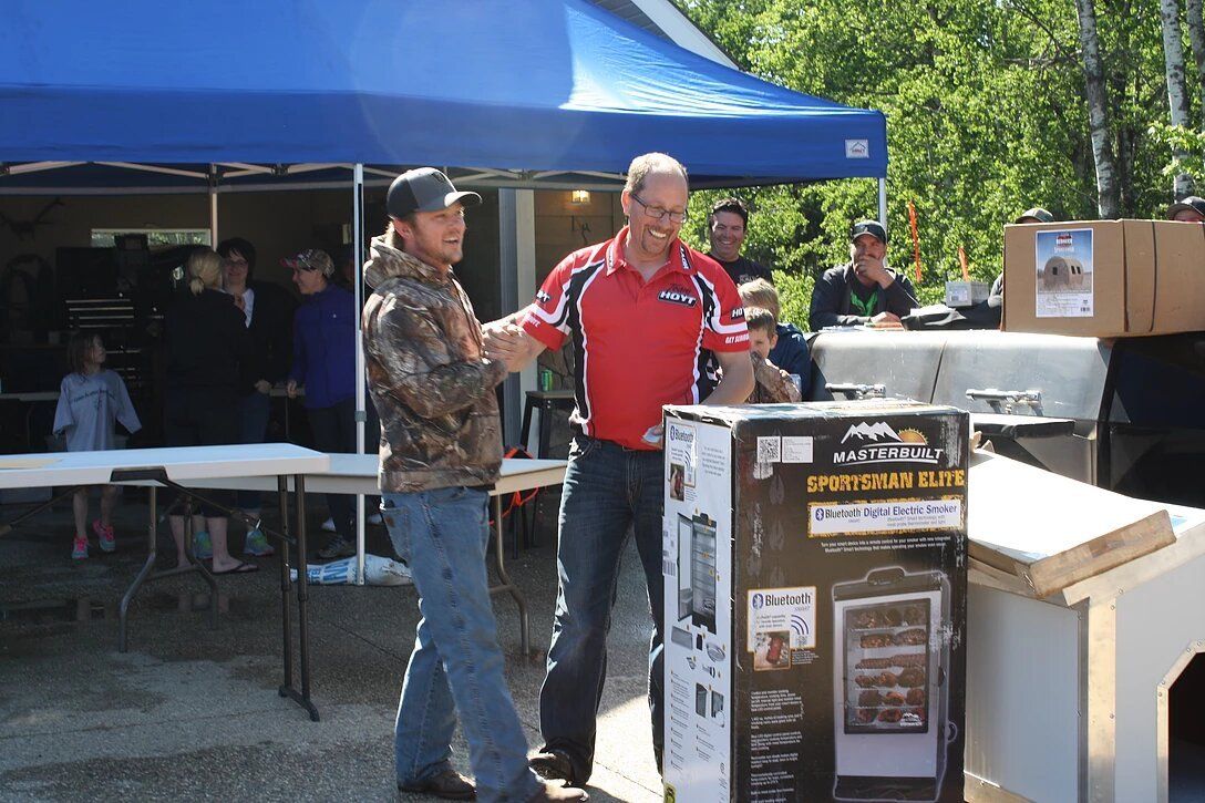 A man in a red shirt is shaking hands with another man