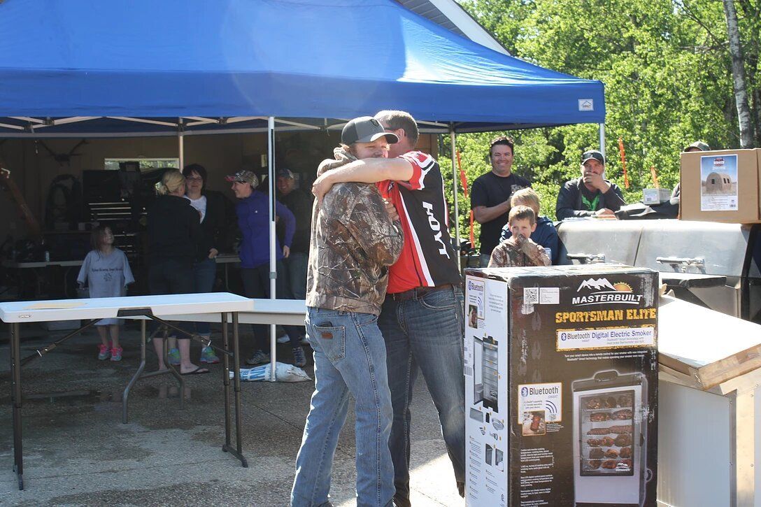 Two men hugging each other in front of a box that says ' lg ' on it