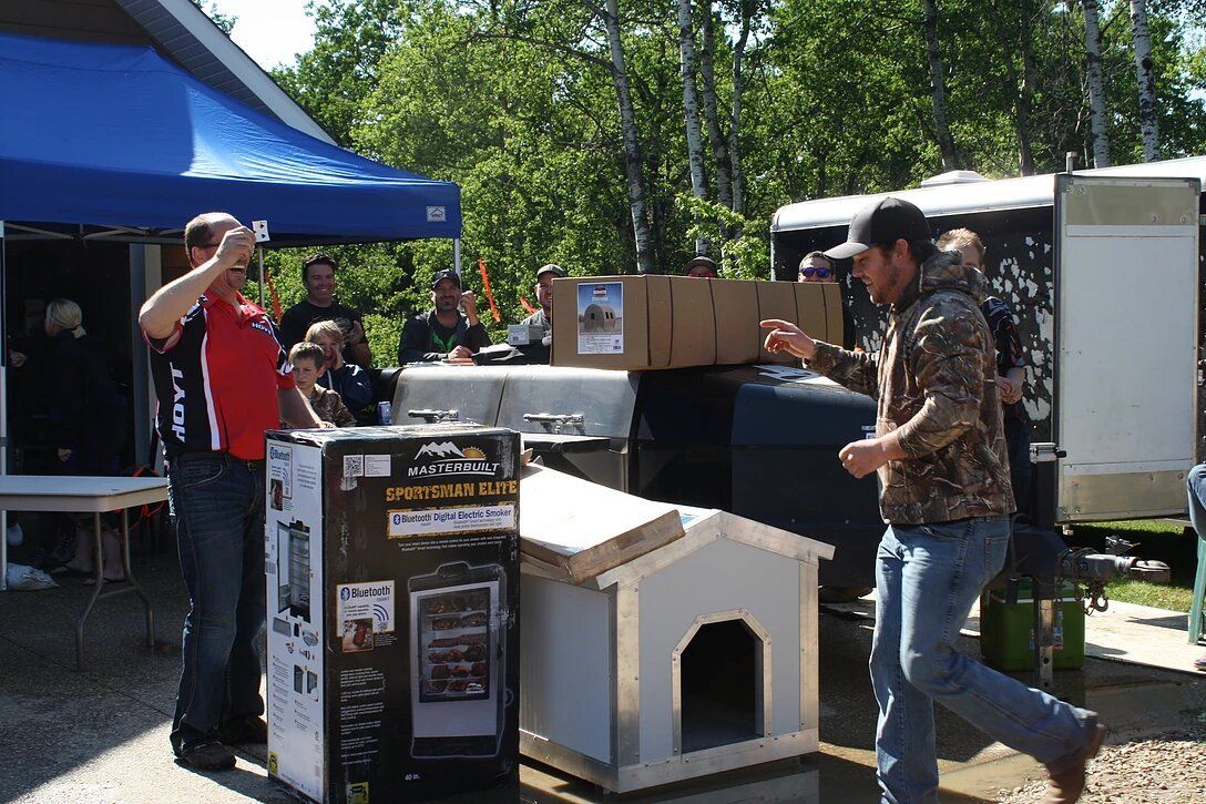A group of people are standing around a dog house.
